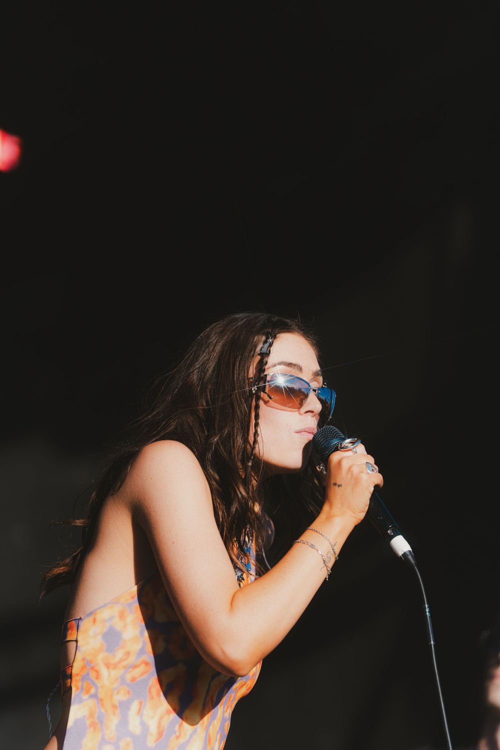 A singer performs passionately on stage in a dark setting while holding a microphone.