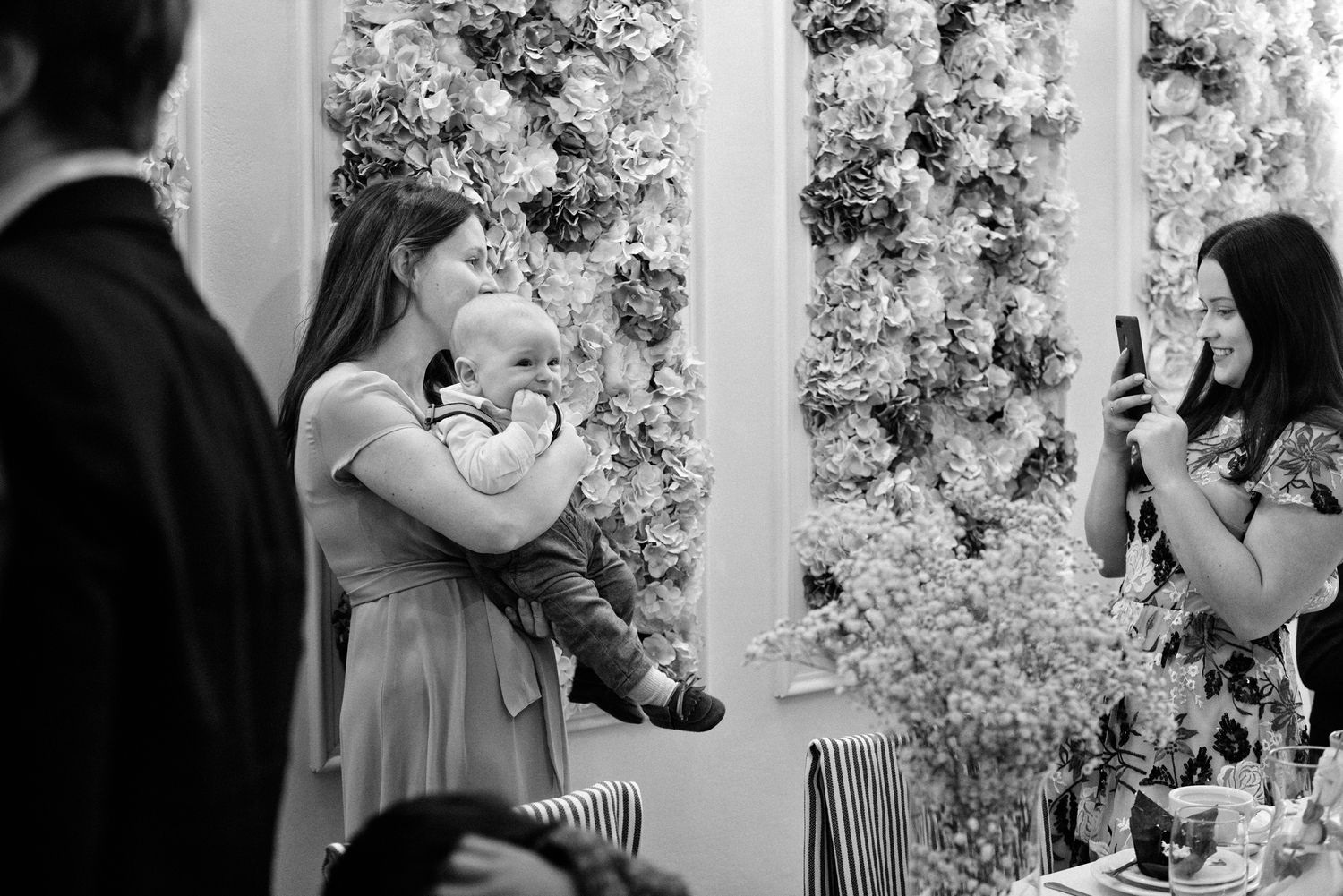A romantic black and white photo sequence shows a couple embracing and kissing against a floral backdrop.