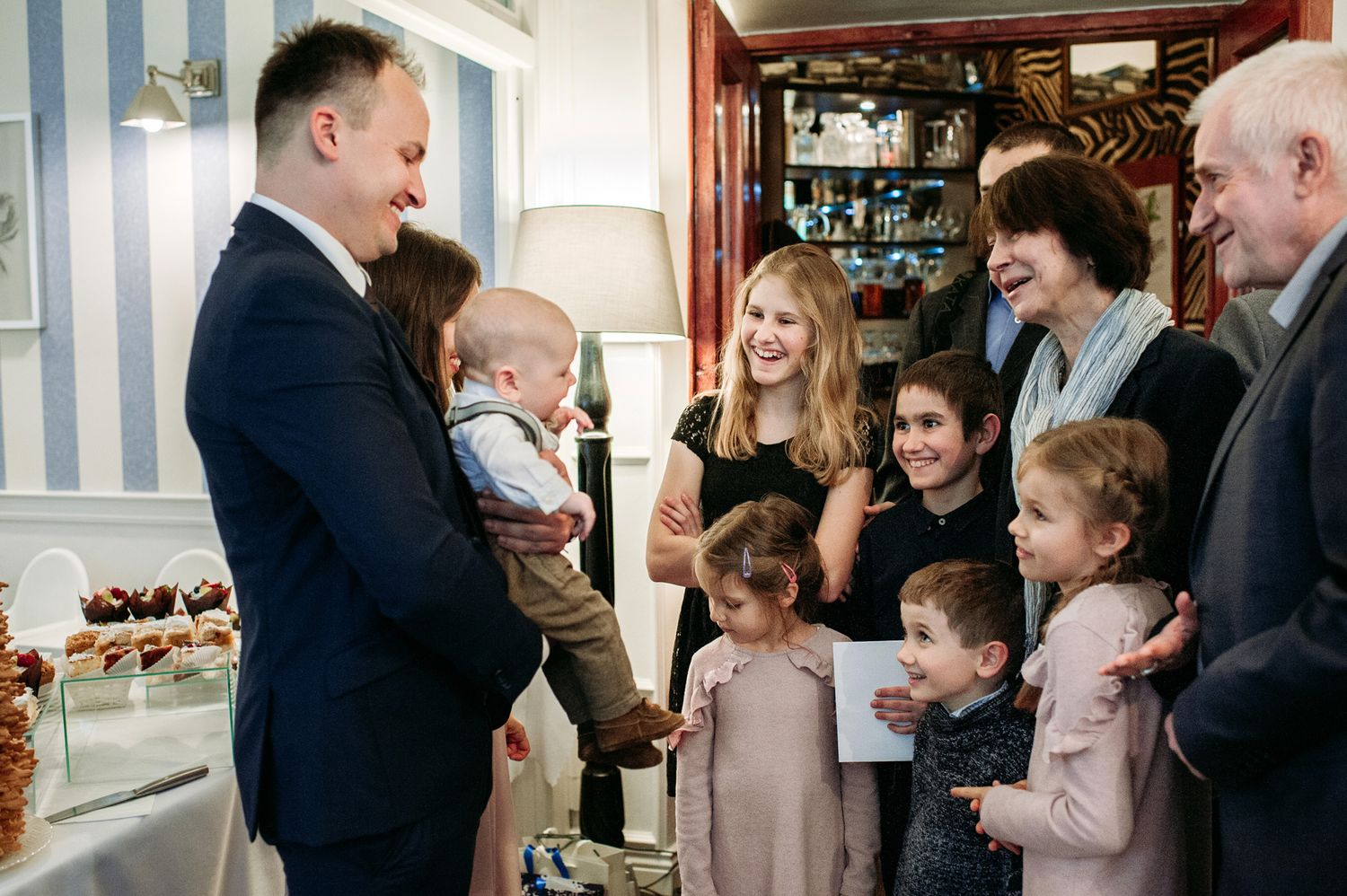 Candid family gathering shows joyful interactions and conversations in a bright indoor space.