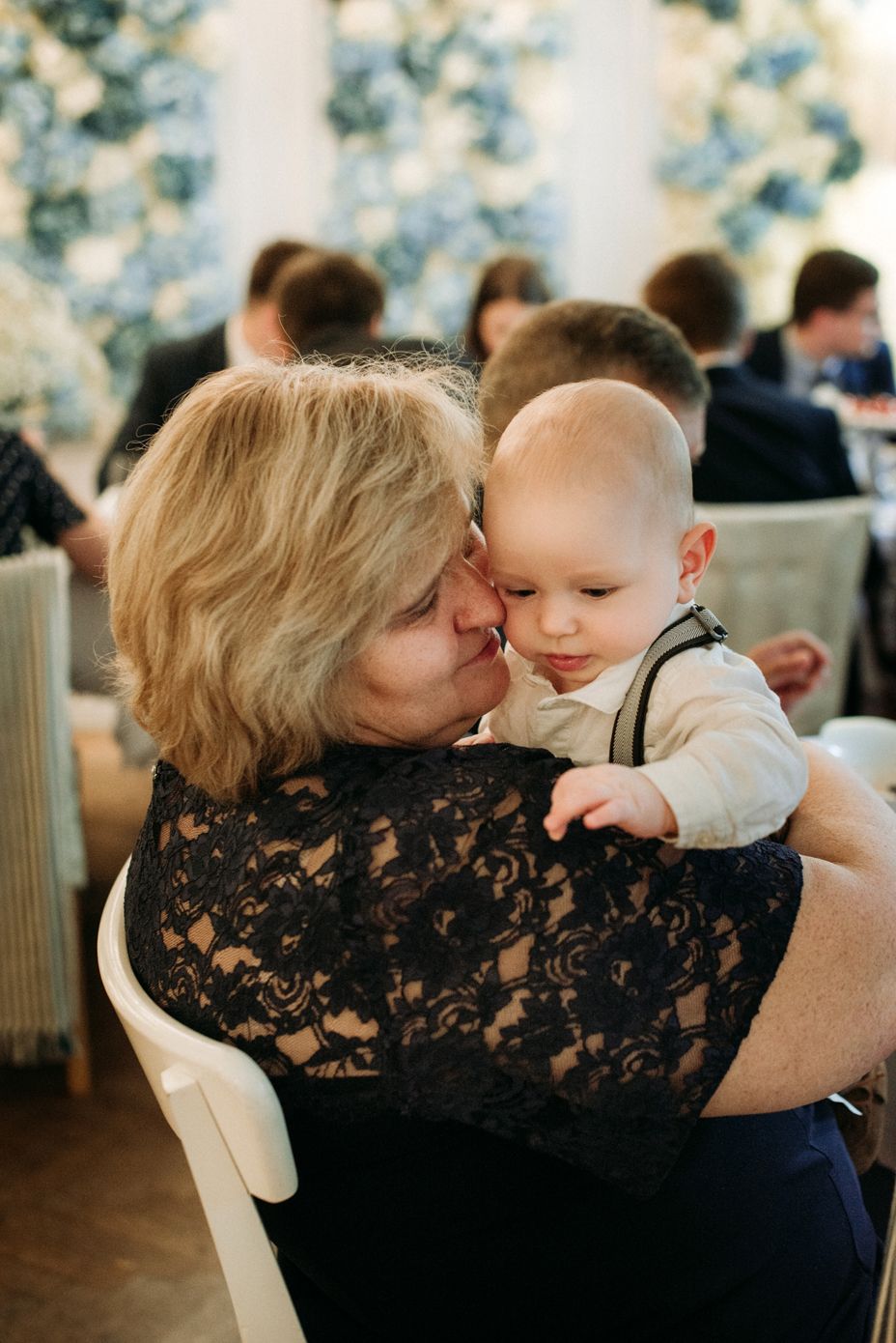 A tender moment between a woman in black lace and a baby as they share loving embraces in multiple candid shots.