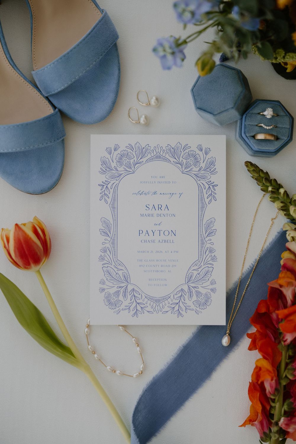 Wedding invitation suite in soft blue tones with floral design and tulip accents.