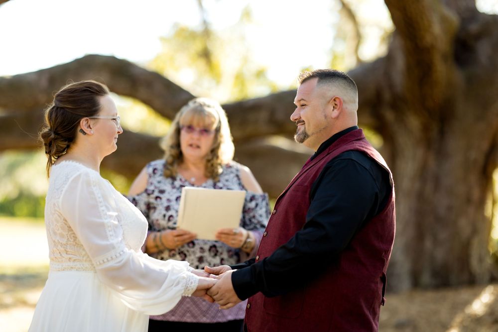 A couple shares a romantic dance together outdoors during a wedding celebration at sunset.