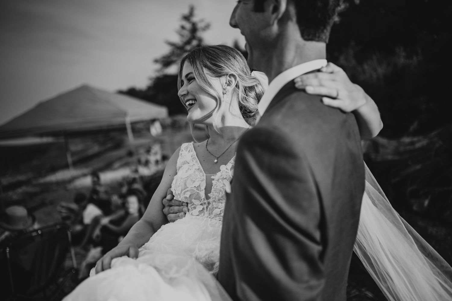 Bridal couple on sandy Williams Beach, groom carrying bride during golden hour wedding portraits with ocean and mountains in background