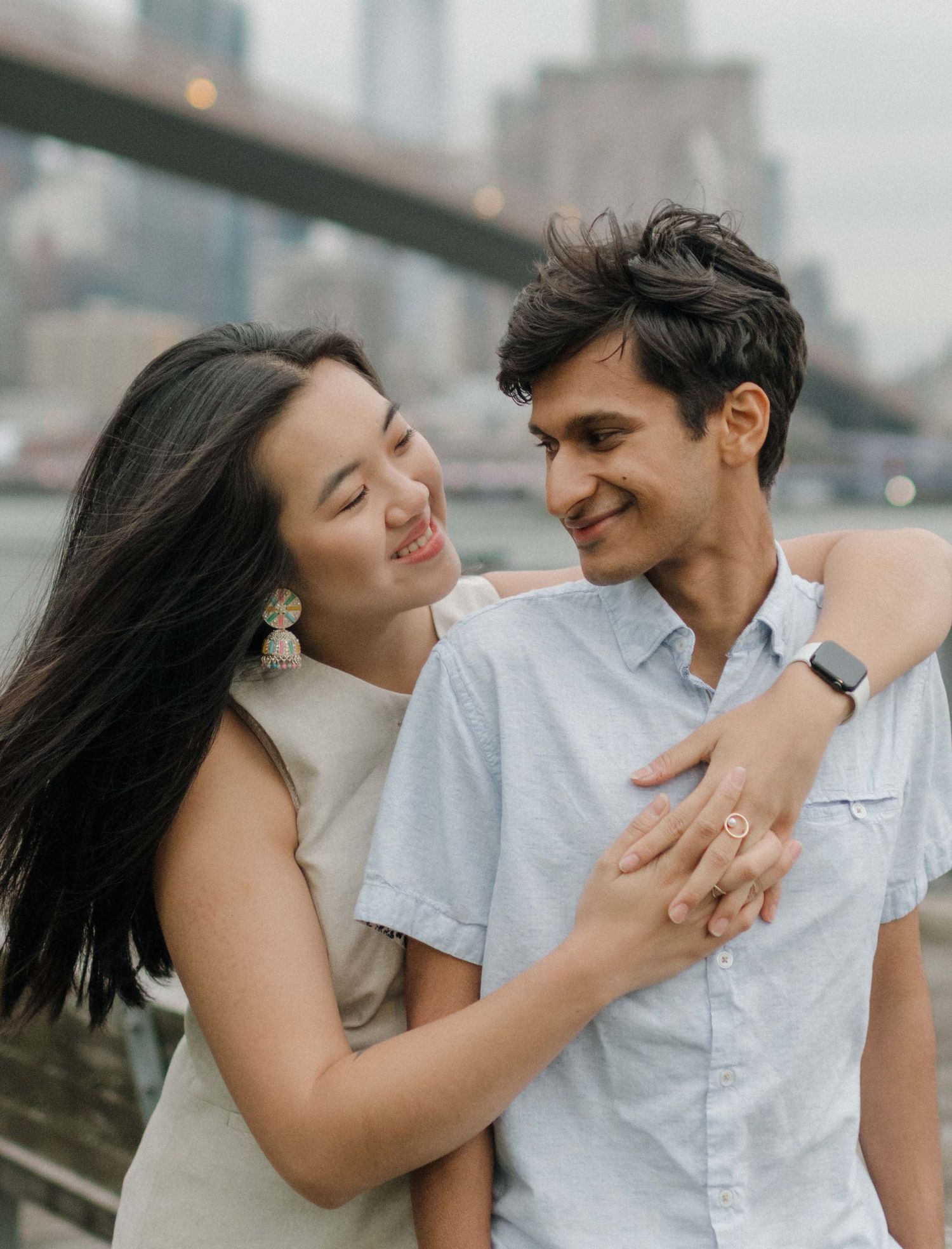 A romantic couple shares intimate moments in a series of candid engagement photos by the waterfront.