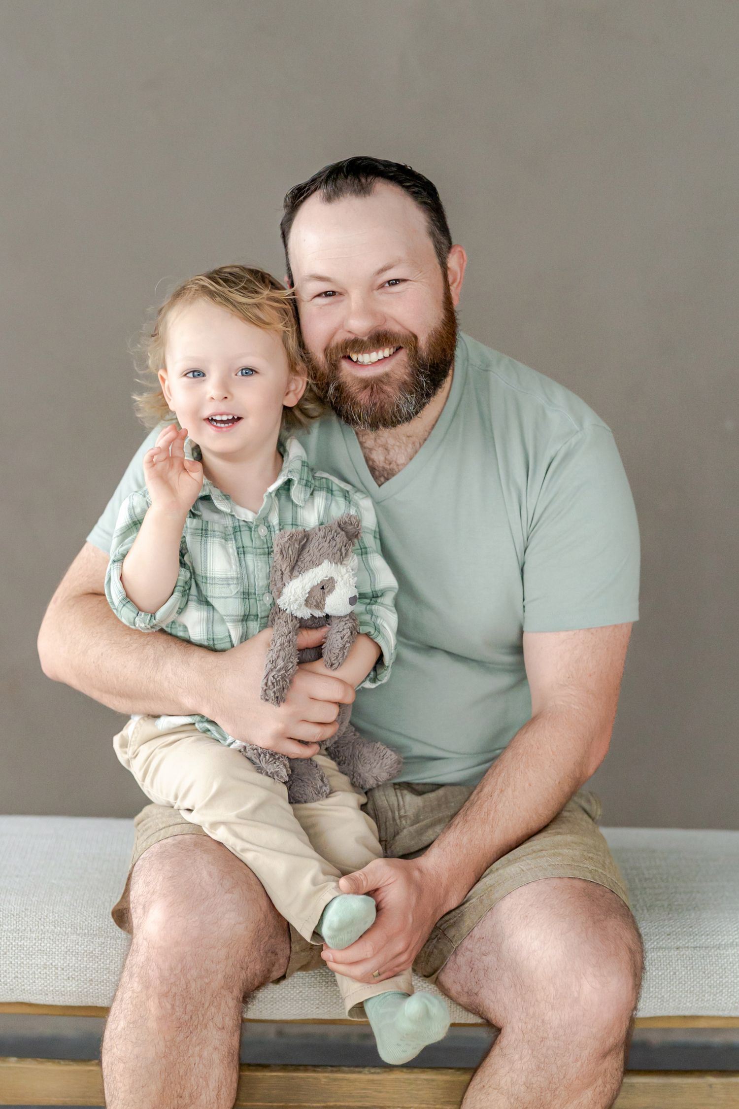 A parent and baby wearing matching mint green outfits share playful moments while sitting together in a photo series.
