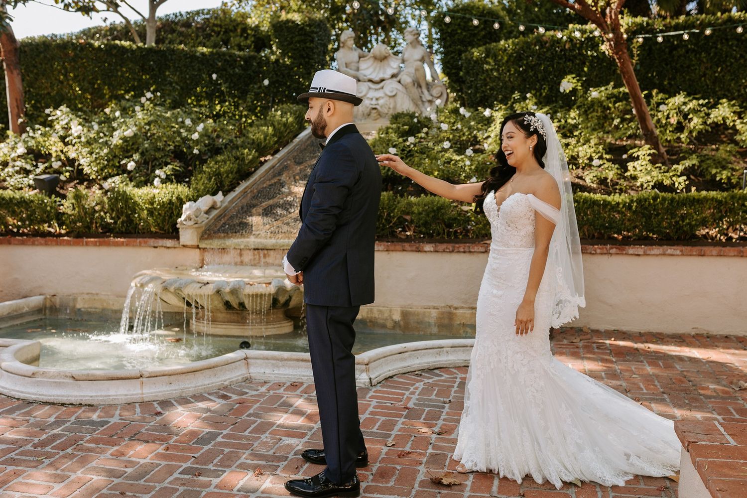 A couple shares a romantic moment on a brick patio surrounded by twinkling lights and lush greenery at Rancho Bernardo Inn.