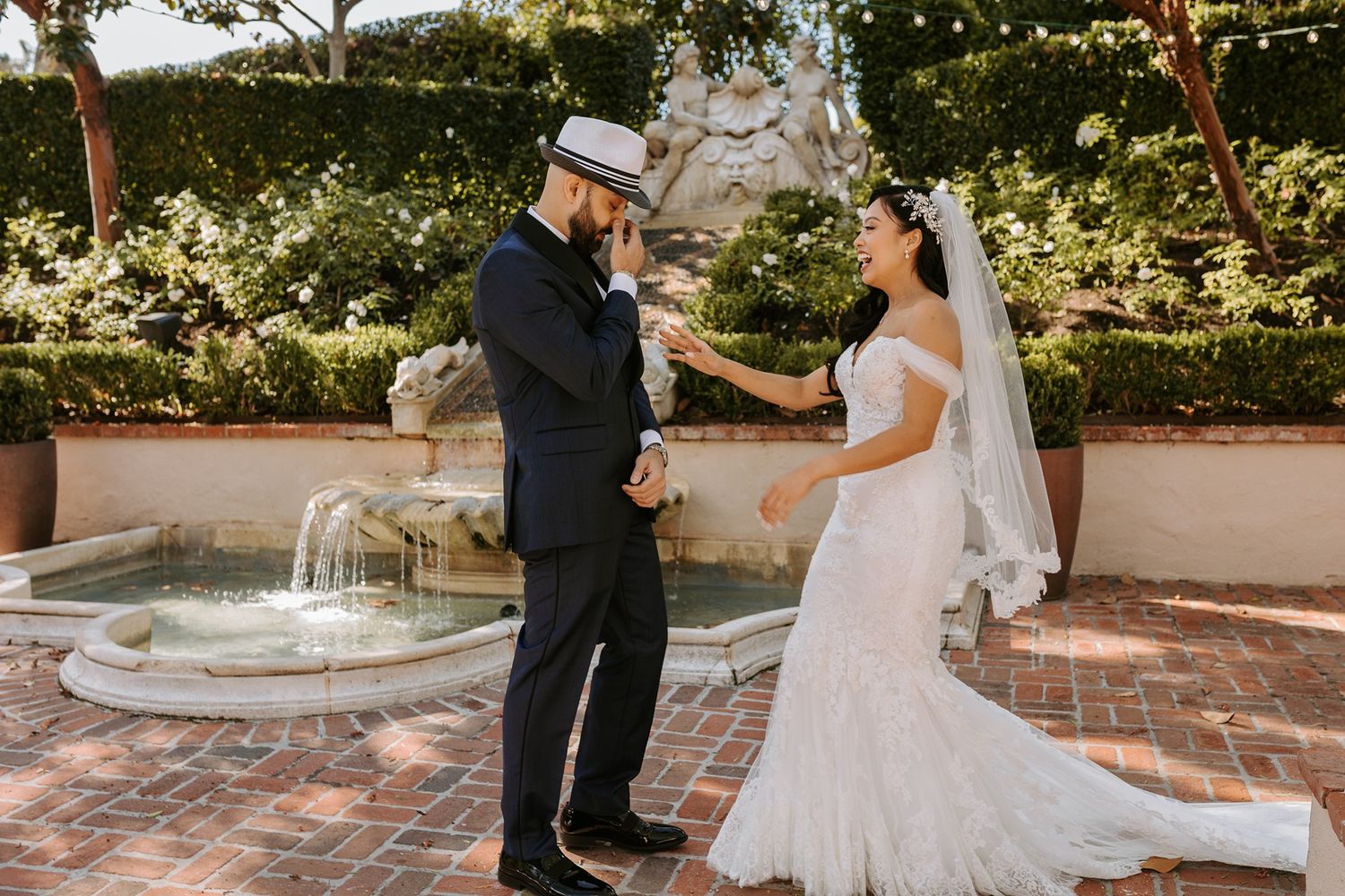 A romantic wedding couple poses in front of a garden fountain on their special day at Rancho Bernardo Inn.