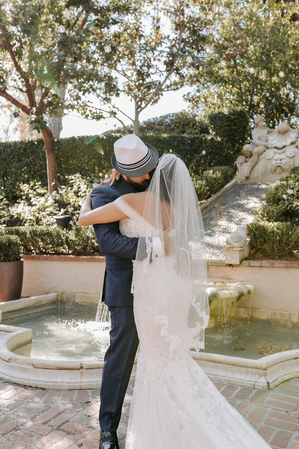 A romantic first look moment between newlyweds at a Mediterranean-style courtyard with a fountain at Rancho Bernardo Inn.