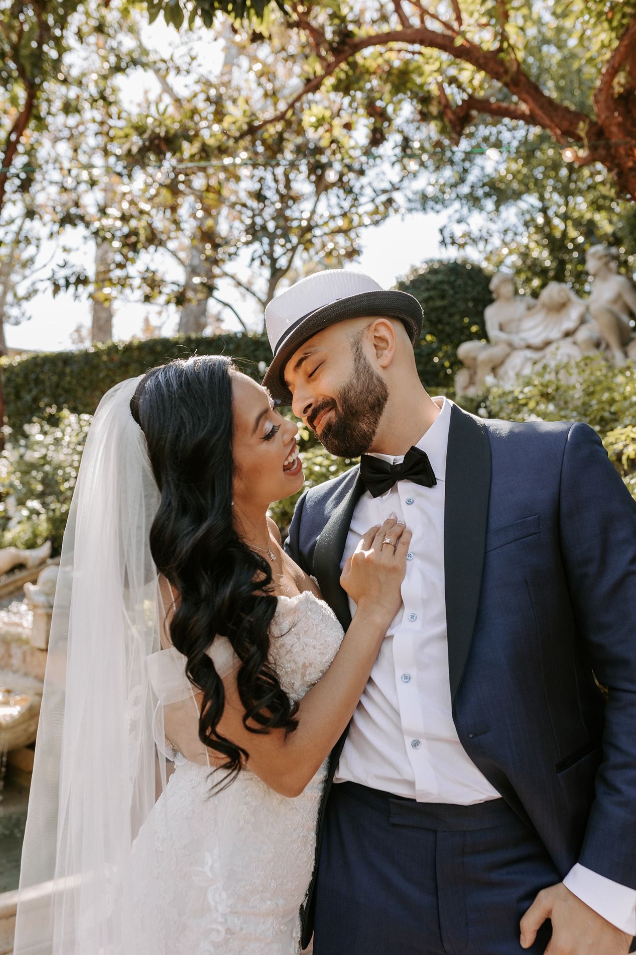 A romantic wedding couple shares tender moments in a series of outdoor portraits under sunlit trees at Rancho Bernardo Inn.