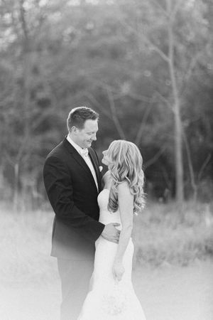 A romantic black and white photo series captures tender moments between a bride and groom outdoors.