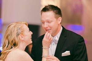 Joyful couple sharing a candid laughing moment while dressed in formal attire at an elegant event.