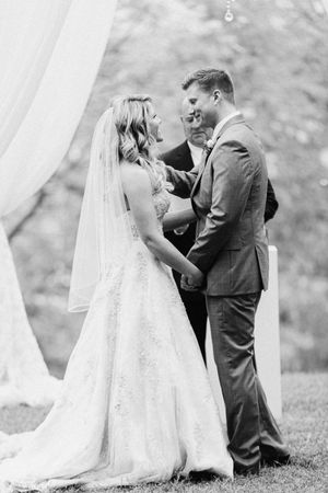 Black and white photo series showing tender moments between newlyweds under white drapery at outdoor ceremony.