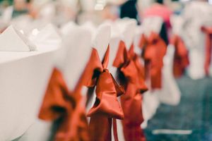 Small origami paper cranes in red and white colors folded and arranged on a reflective surface in a pattern.
