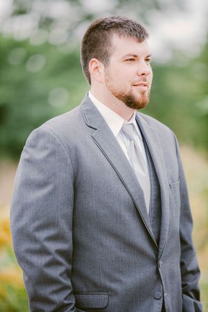 Close-up portraits of someone in a gray suit jacket and white dress shirt with a clean, well-groomed beard.