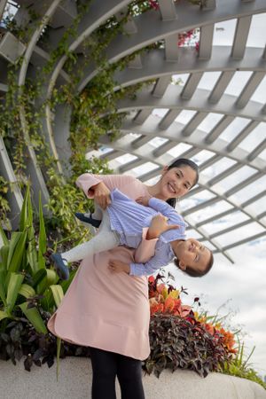 Joyful moments captured in a garden pergola with tropical plants and flowers.