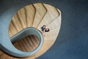Modern spiral staircase with wooden steps and blue walls photographed from above.