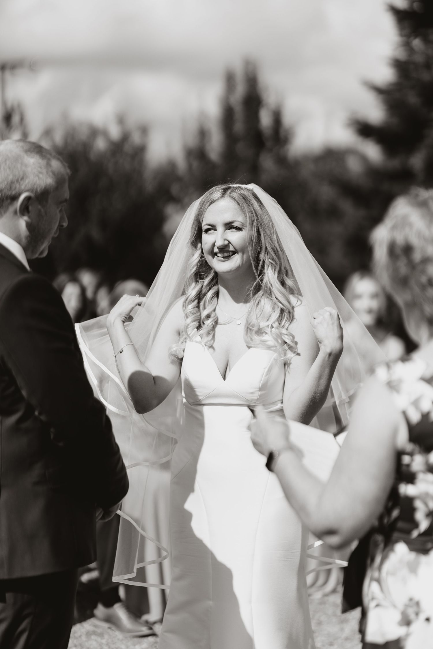 A sequence of joyful wedding party moments in black and white shows celebration and dancing at an outdoor ceremony.