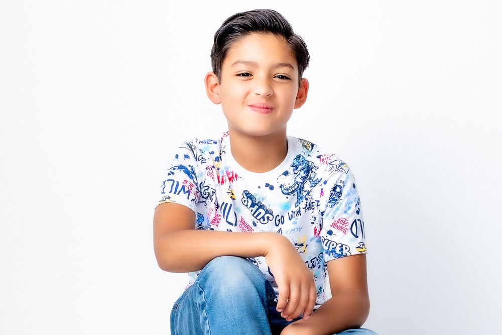 Collage of three shots showing someone wearing a white patterned shirt while posing and smiling against light backgrounds.