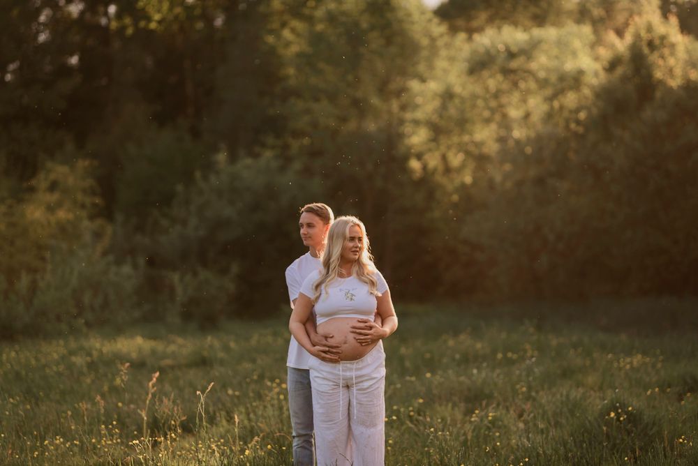 Intimate maternity photography session captures tender moments between expecting parents at sunset.