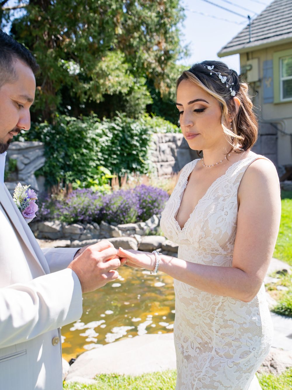 Intimate ring exchange moments during an outdoor summer wedding ceremony with garden backdrop.