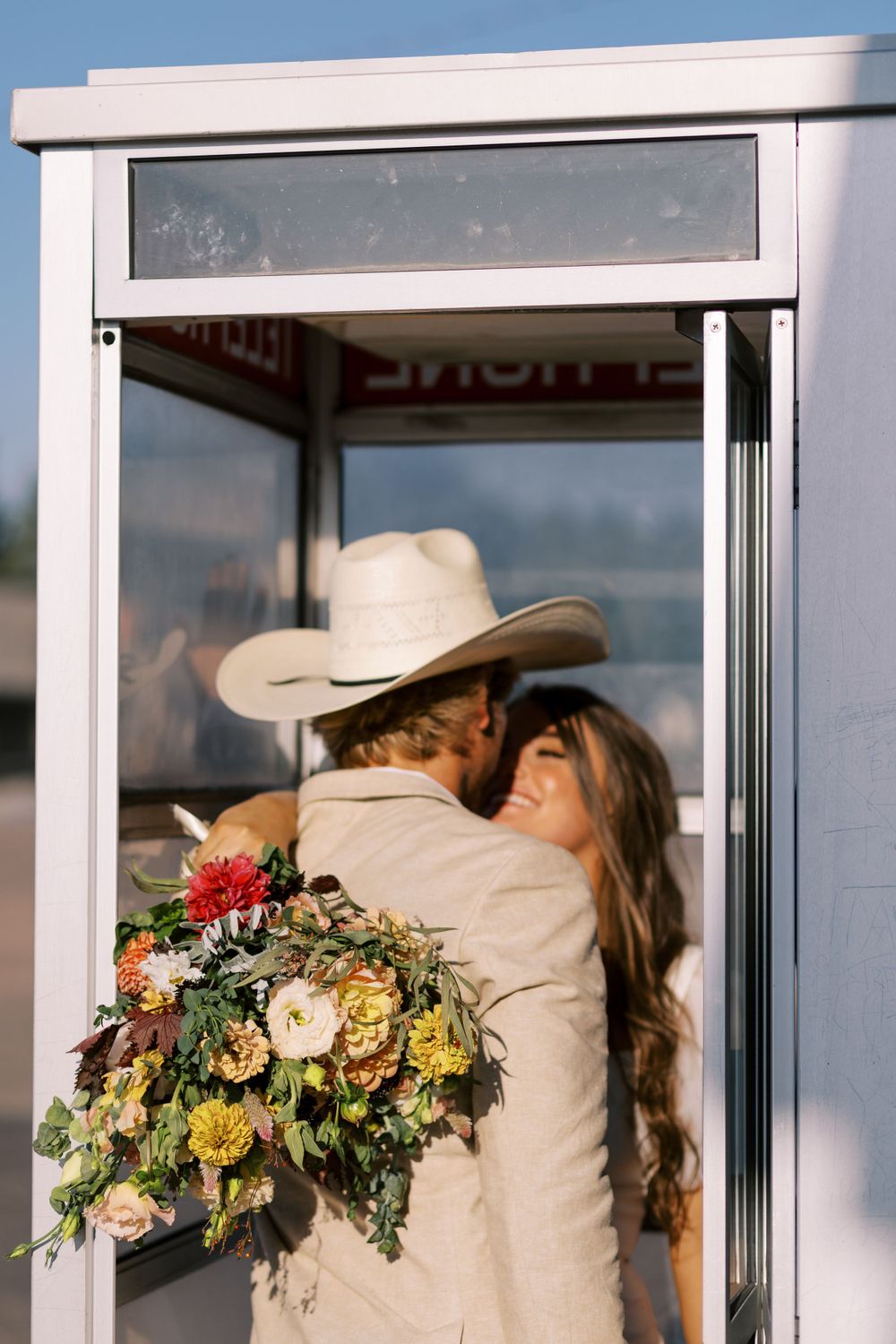 Romantic moment captured in doorway with beautiful floral bouquet.