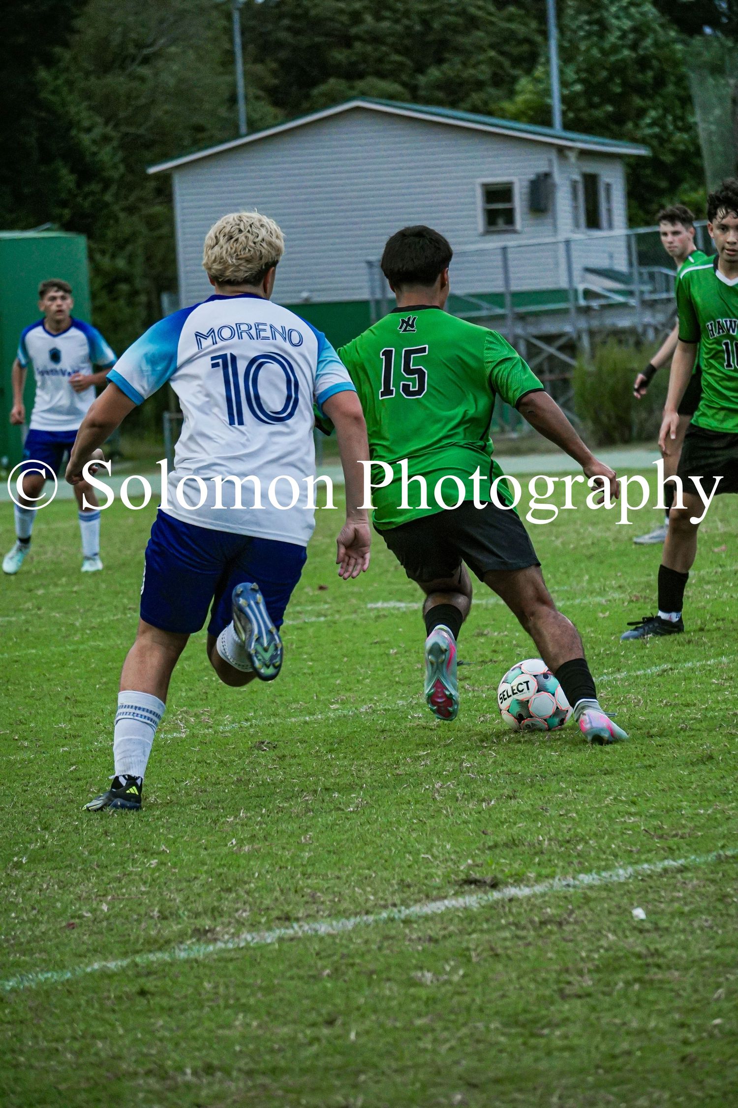 Soccer player Moreno wearing number 10 competes against a green-jersied player number 15.