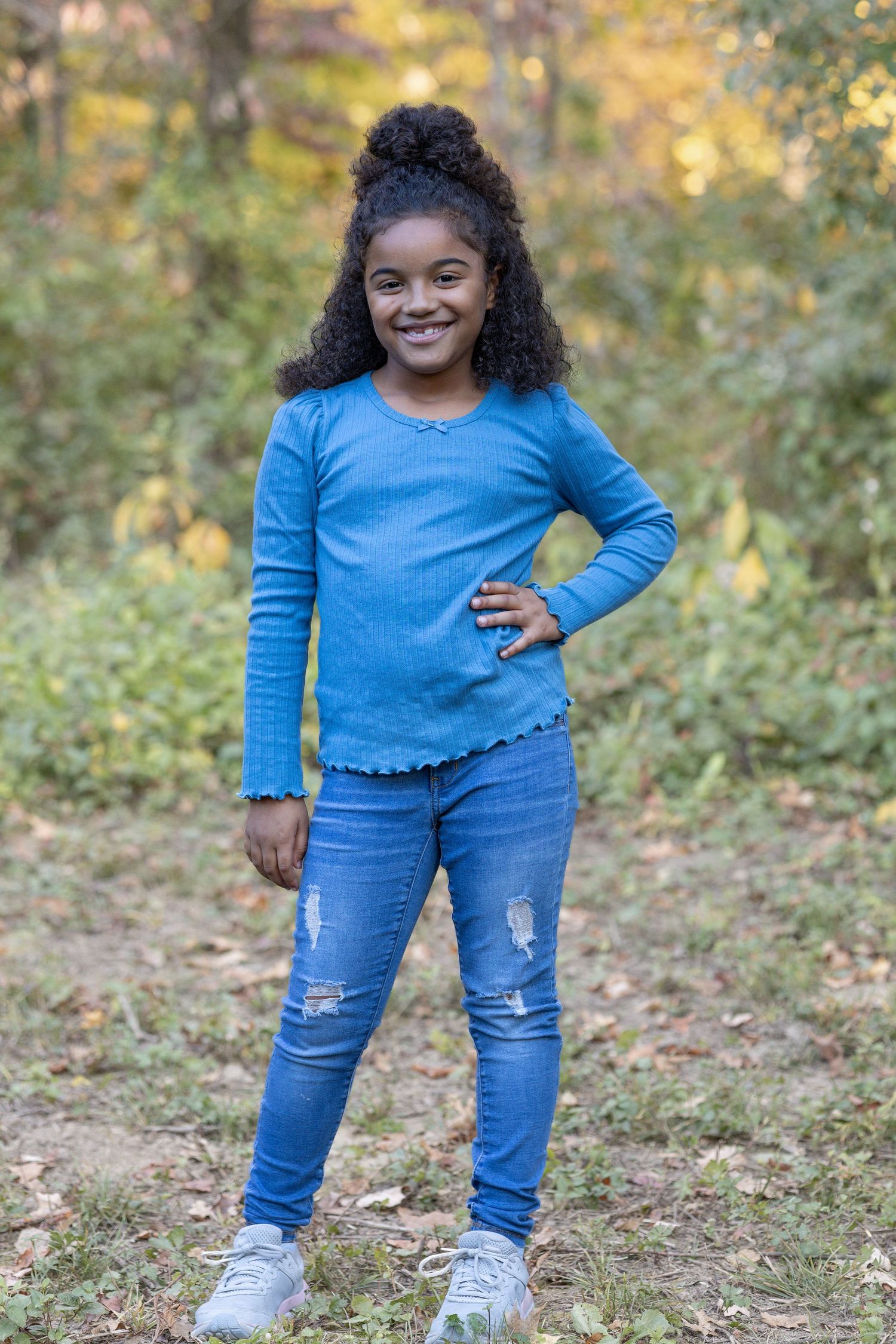 Springfield, IL family photographer captures a young girl smiling with her hand on her hip during a photo session in Central, IL