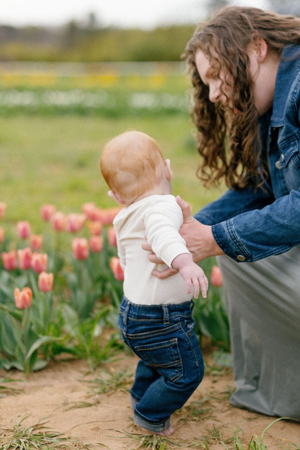Four sequential photos show a small child touching tulips in a garden while wearing denim overalls and white top.