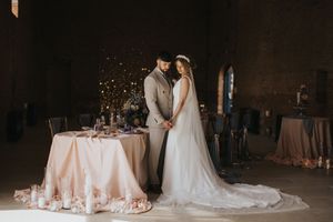 A romantic wedding table setting with pink and white decor details in an elegant rustic venue.