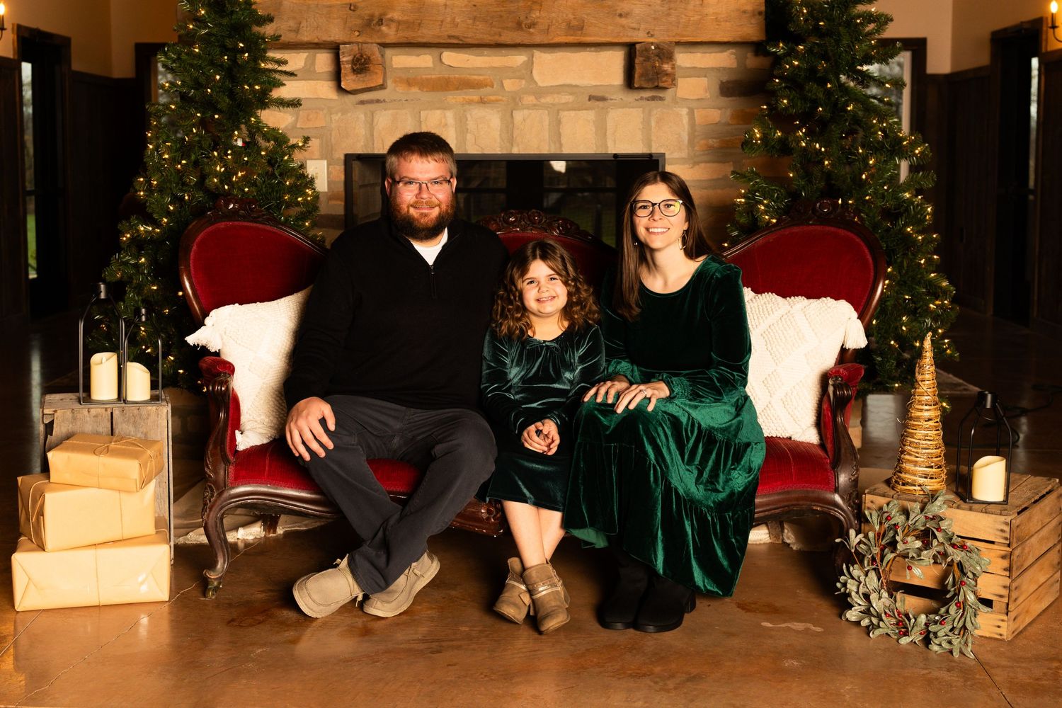 A decorated Christmas scene with evergreen garlands and golden lights in a cozy indoor setting.