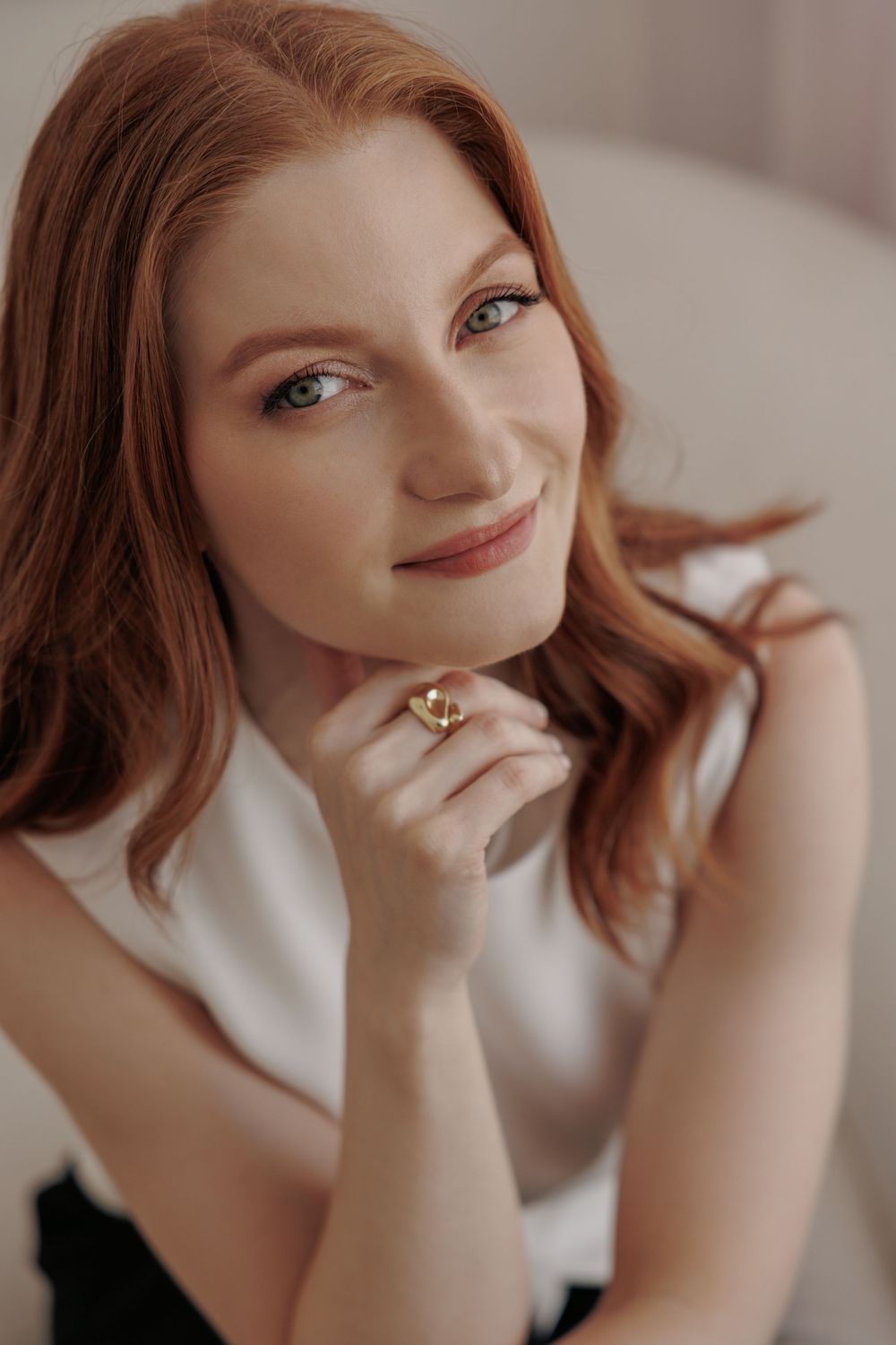 A person in a soft sepia toned portrait sequence shows subtle movements and expressions while wearing minimal jewelry.