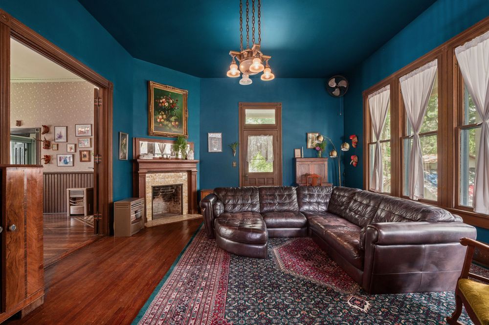 Six connected panoramic views of an elegant Victorian-style room with blue walls, ornate rugs, and dark wood furnishings.