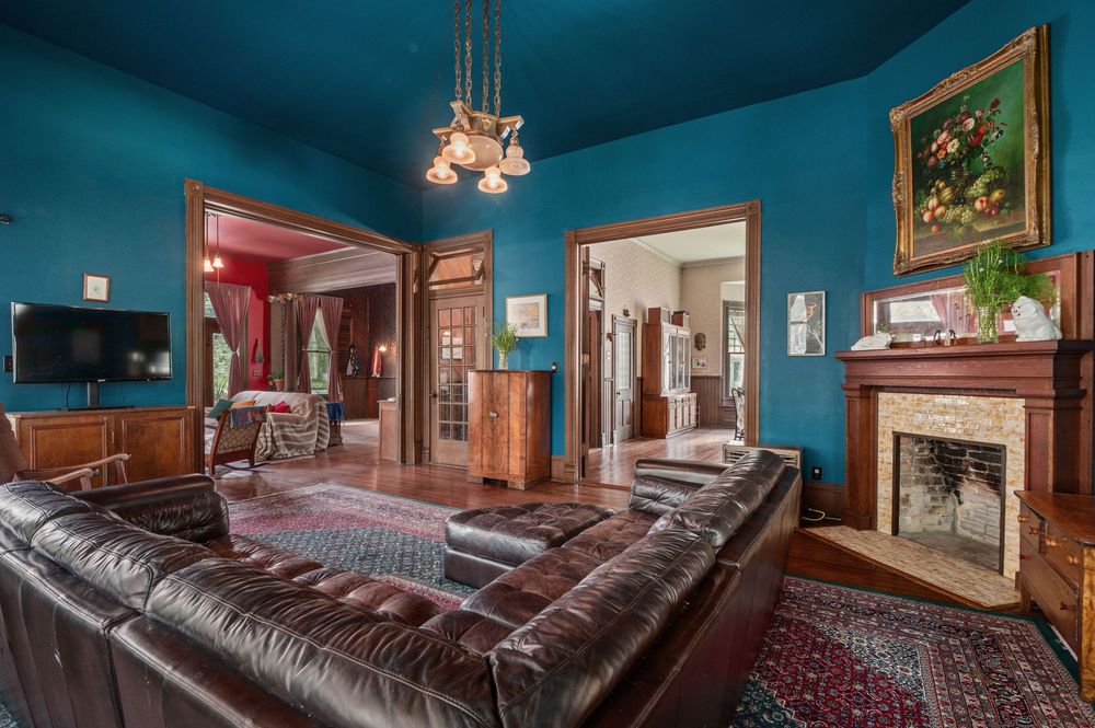 Blue-walled sitting area featuring leather seating, wall art, and wooden trim details.