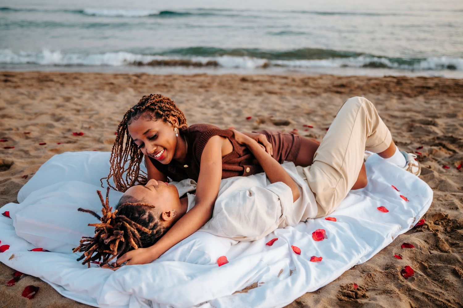 Couple dancing in the sand post-proposal