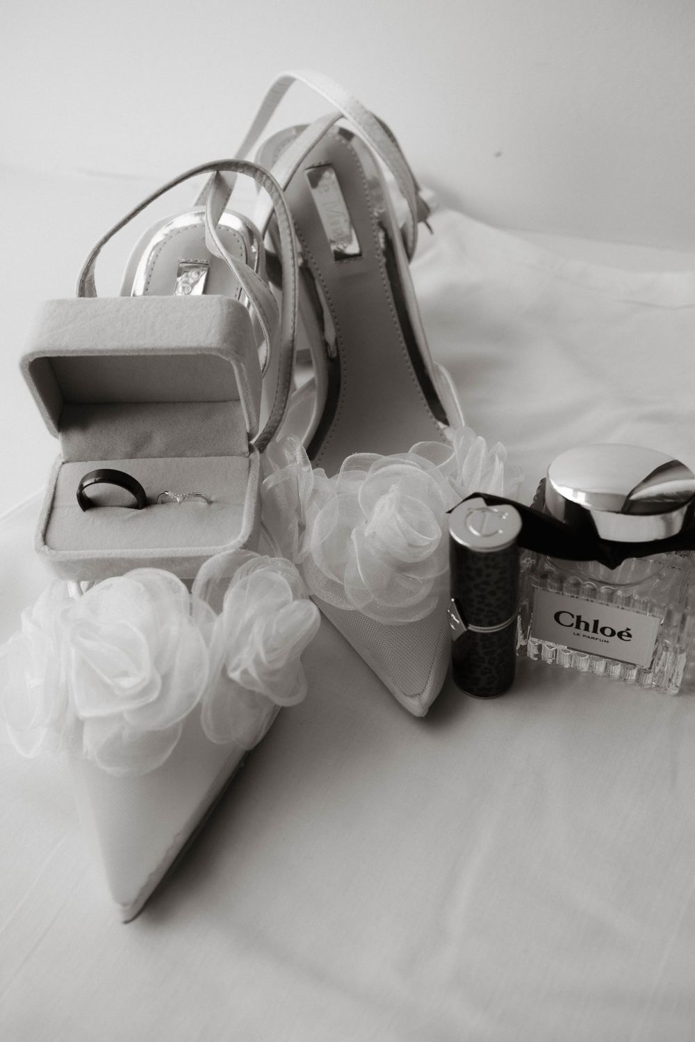 Wedding flat lay with bridal shoes, perfume, and rings, styled for editorial wedding photography at Holmes Mill by Manchester photographer.