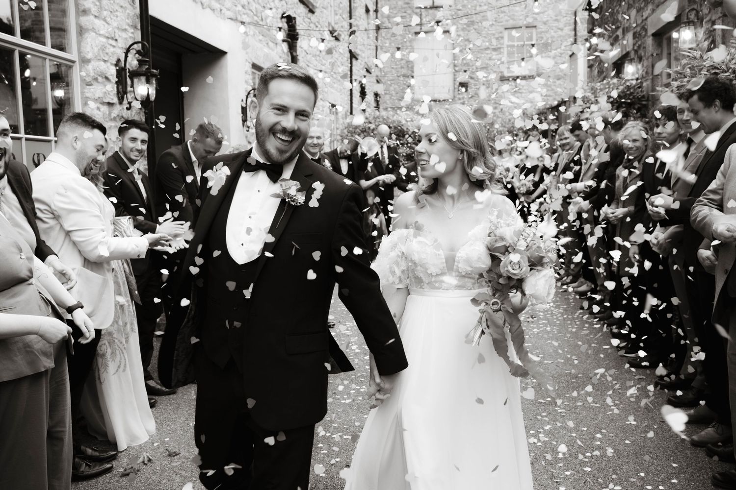 Confetti moment outside Holmes Mill venue, captured with natural light and documentary wedding photography style in Lancashire.