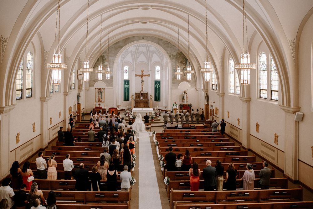 Traditional church wedding ceremony in a beautiful arched cathedral with stained glass windows.