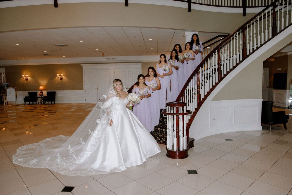 Grand staircase venue decorated for wedding with flowing white dress on display.