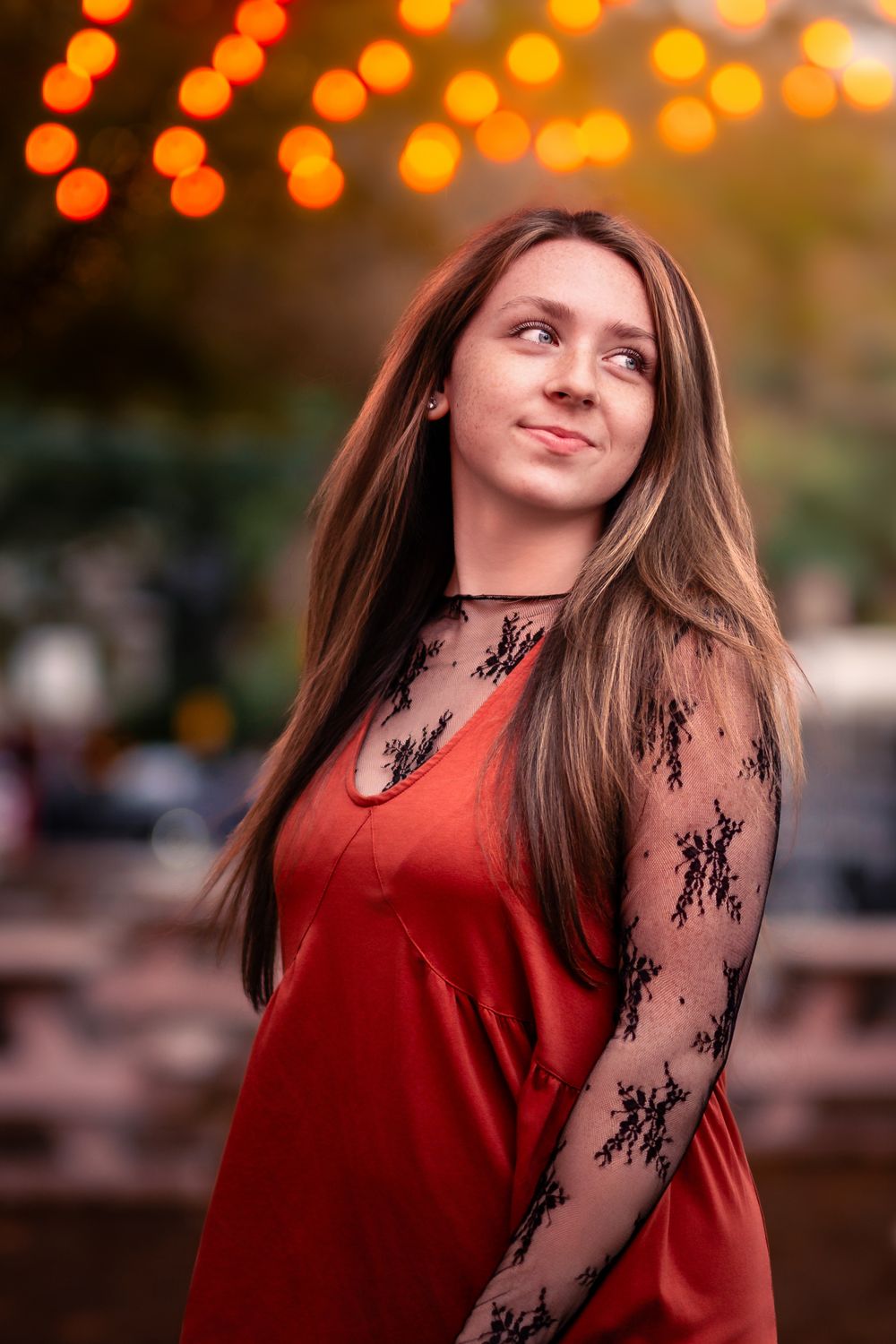 A series of photos showing someone in a red velvet top with black lace sleeves against a bokeh background at sunset.