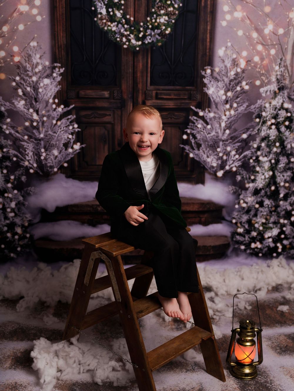 Child in black sweater sits on wooden bench amidst snowy winter wonderland scene with glowing lantern and cherry blossoms.