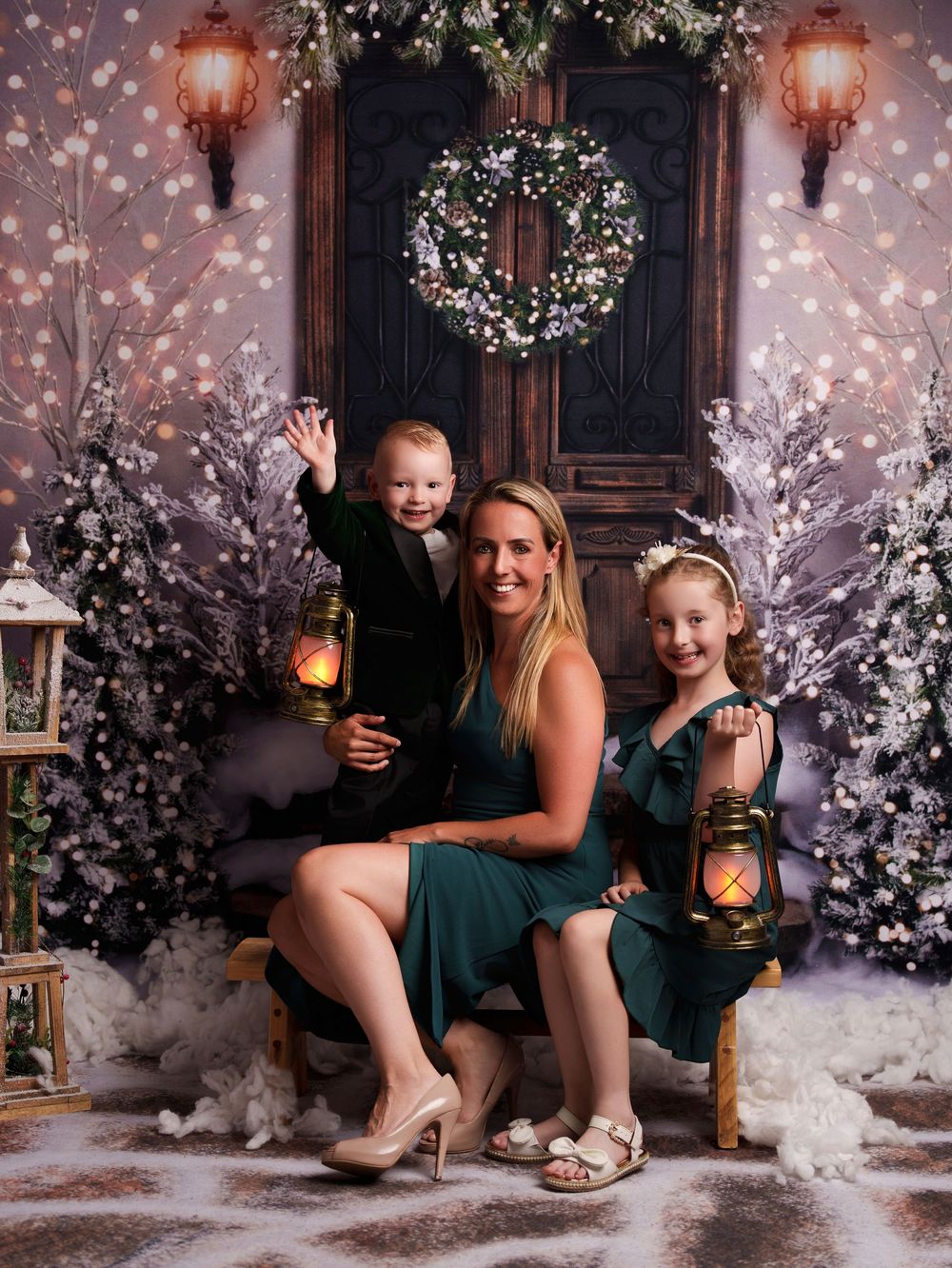 Winter wonderland photo session with lanterns, white flowers, and snowy decor in a cozy indoor setting.