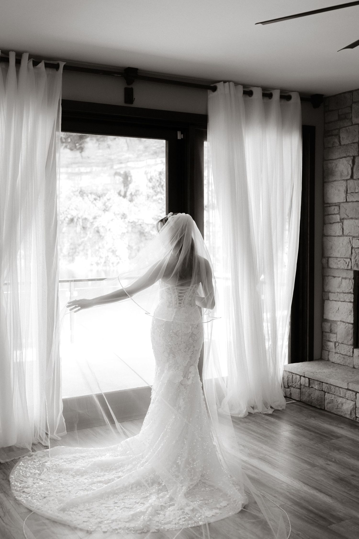 Series of bridal portraits in flowing white dress against sunlit white curtains and brick walls.
