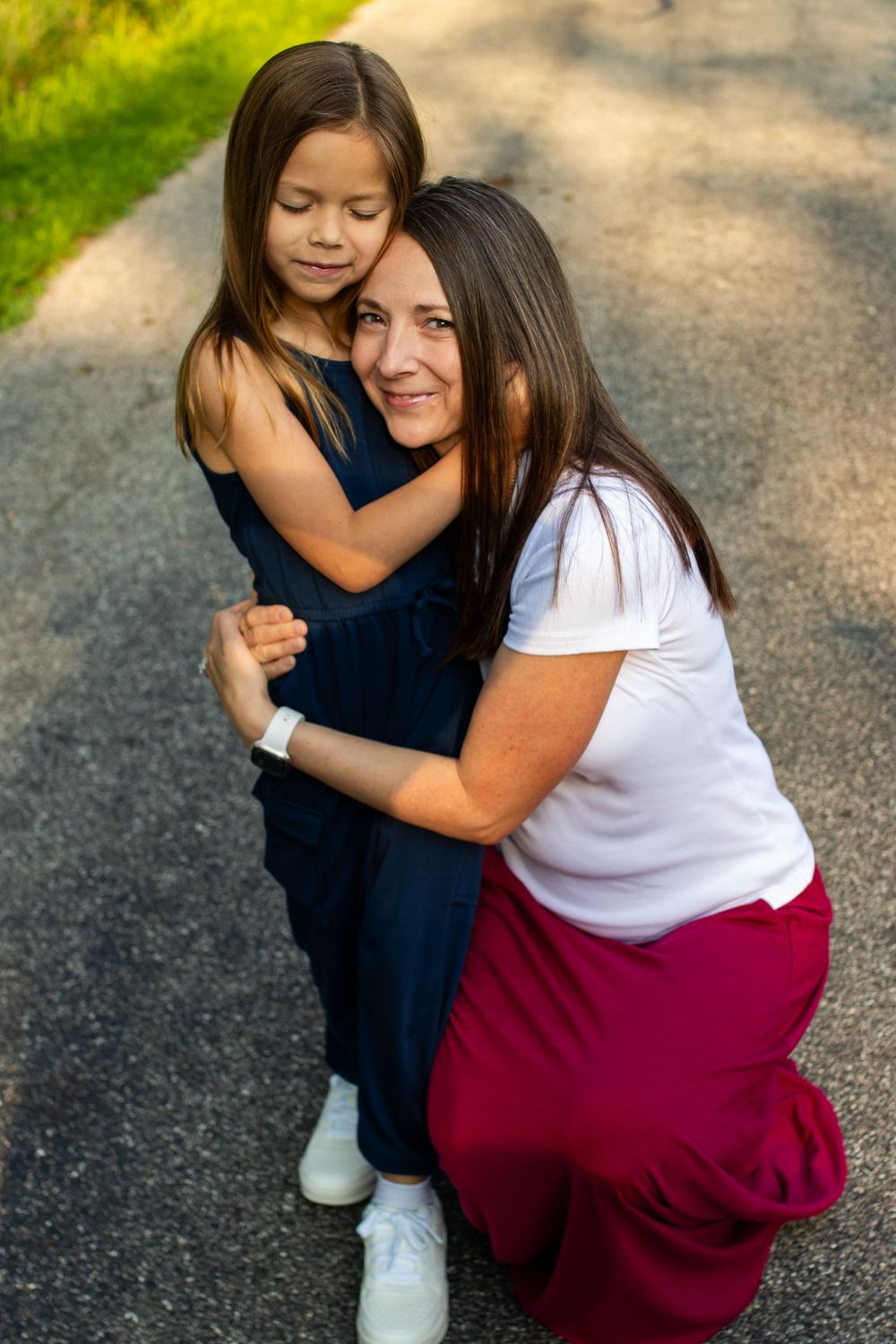 Heartwarming embraces shared on a sunny path with natural lighting.