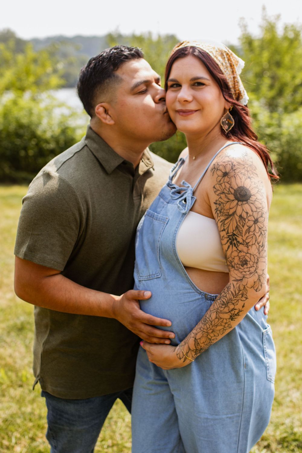 Couple in casual attire sharing intimate moments in a sunlit outdoor setting.