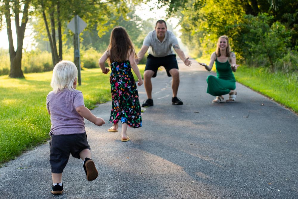 Group walking together on gravel path during golden hour outdoor photo session.