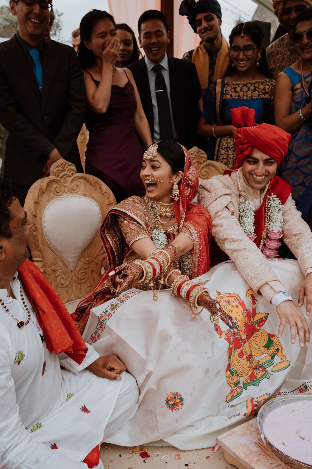 bride and groom playing 'find the rice' at a traditional and colourful Indian wedding