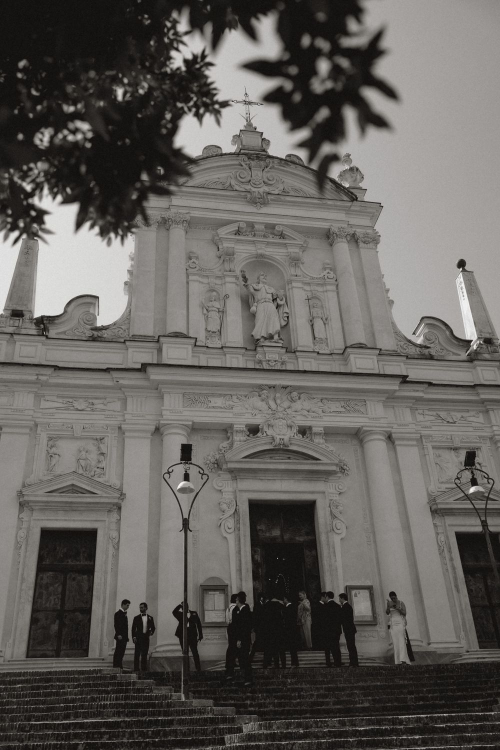 Black and white photo of a grand Italian baroque church facade with ornate architectural details in portofino
