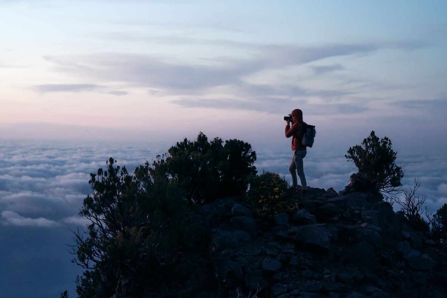 Randonneur au dessus de la mer de nuages au pico ruivo à Madère au coucher du soleil