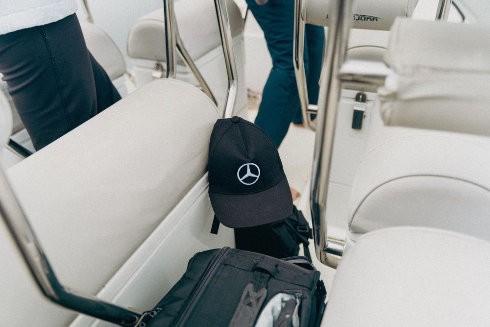 Interior of a luxury boat showing white leather seats and a Mercedes-Benz logo.