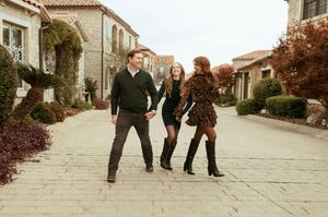 A group walks together along a paved pathway with Mediterranean-style buildings in the background.